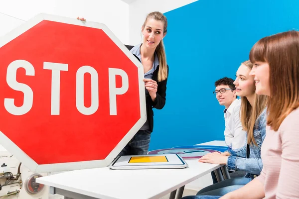 Profesor de conducción explicando el significado de las señales de calle a la clase —  Fotos de Stock