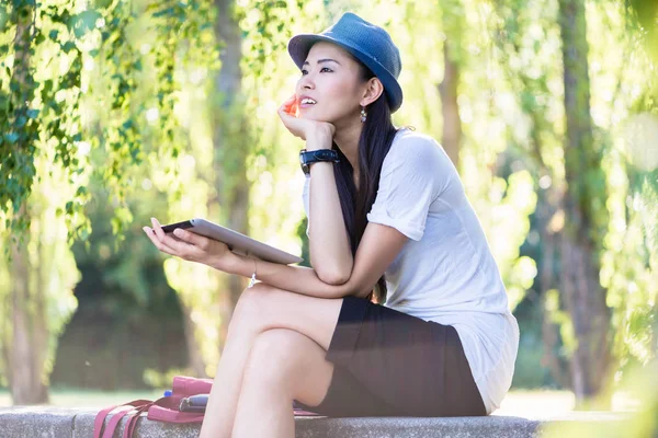 Asiatisk kvinna använder en tablet Pc utomhus — Stockfoto