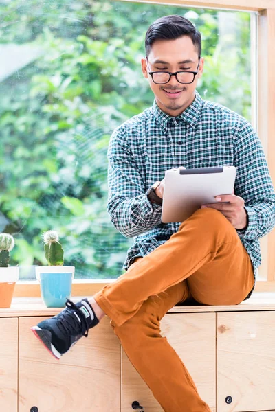 Junger asiatischer Mann surft im Internet auf einem Tablet-PC im Büro — Stockfoto