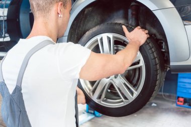 Bir lastiği tutan bir yetenekli otomatik mekanik el düşük açılı görünüş