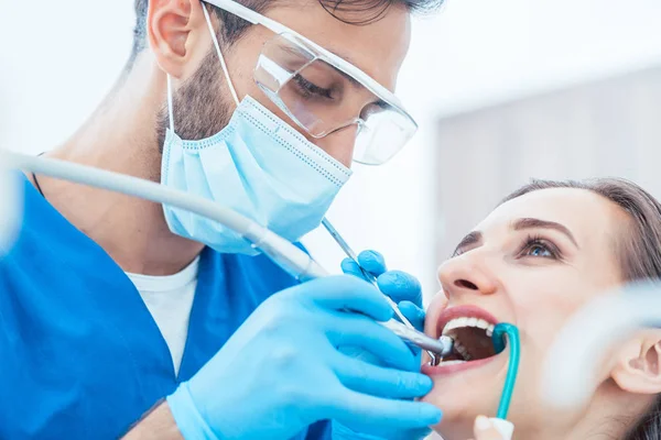 Jovem mulher durante tratamento oral indolor em um consultório odontológico moderno — Fotografia de Stock