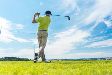 Tam uzunlukta dikiz kulüp sürüş bir swing golf bireysel oyun açık havada sırasında profesyonel bir yere oynarken, Son'u pozisyonda tutan bir adam