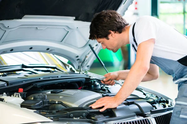 Mécanicien automobile travaillant dans l'atelier de service de voiture — Photo