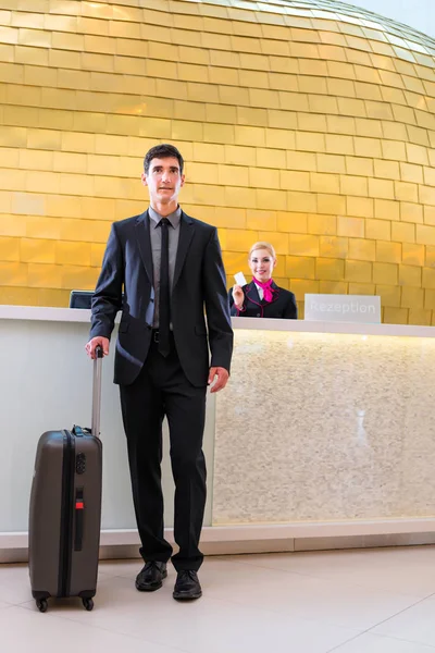 Uomo in partenza per un viaggio d'affari alla reception dell'hotel — Foto Stock