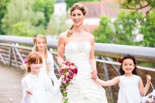 Sposa in abito da sposa con damigelle sul ponte — Foto Stock