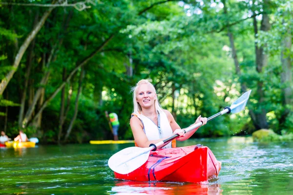 Kvinnan paddling med kanot på forest river — Stockfoto