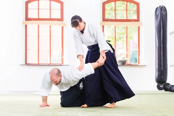 Homem e mulher lutando na escola de artes marciais Aikido — Fotografia de Stock