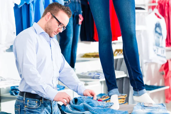 Красивый мужчина покупает синие джинсы в магазине или магазине — стоковое фото