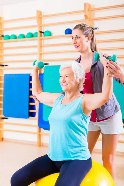 Mujer mayor con entrenador en el deporte fitness — Foto de Stock