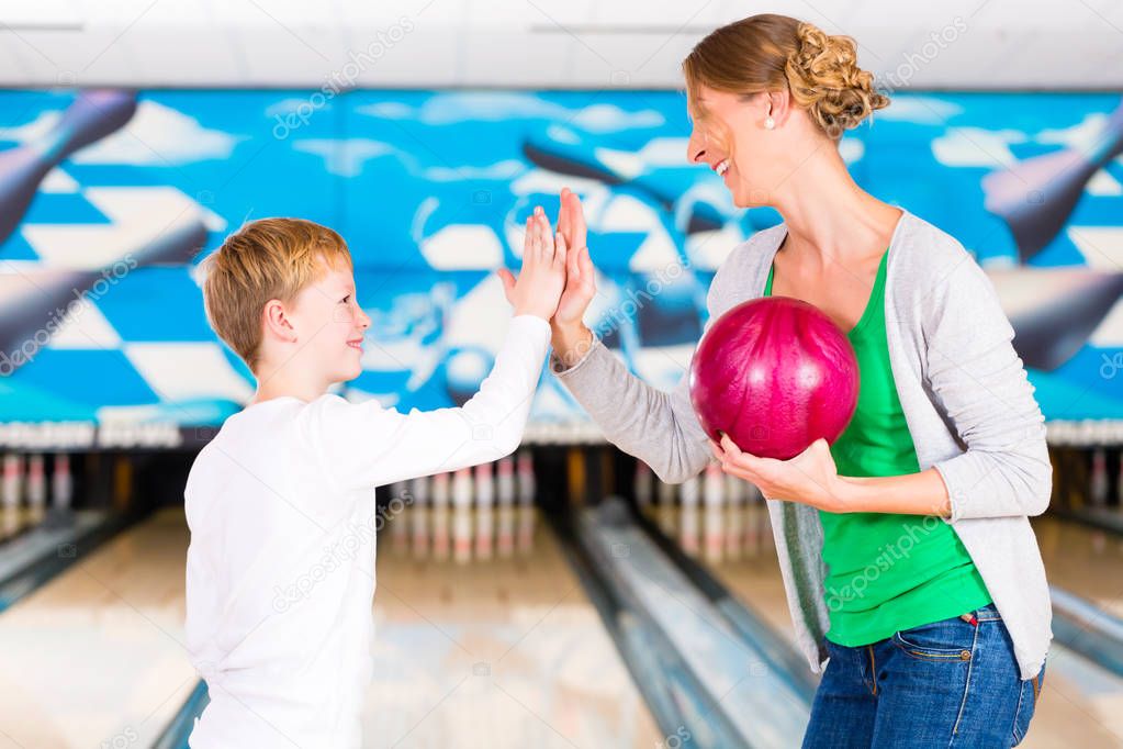 Mother and son playing together at bowling center