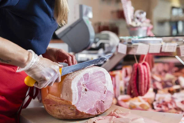 Erfahrene Fleischereifachverkäuferin Schneidet Schinken — Stockfoto
