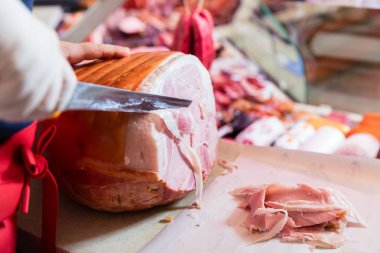 Kasap tezgâhtar kesme jambon satmak için deneyimli 