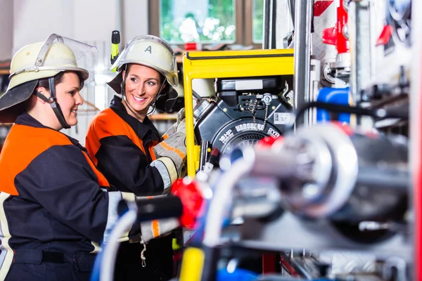 Feuerwehrleute laden Schläuche in Einsatzfahrzeug — Stockfoto