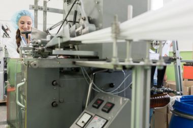 Sırasında gülümseyen kadın üretim teknisyeni