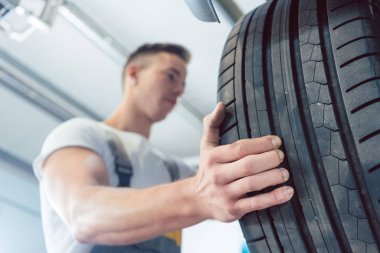 Bir lastiği tutan bir yetenekli otomatik mekanik el düşük açılı görünüş