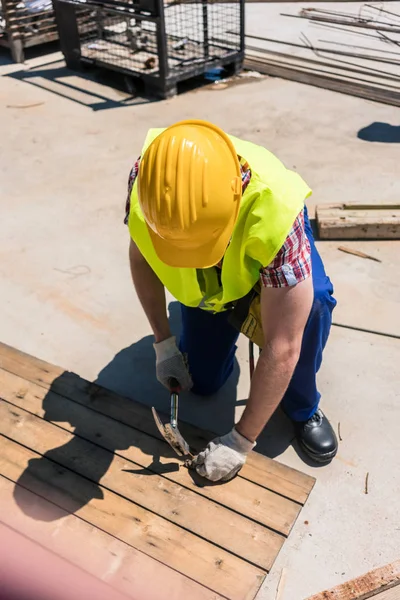 Vista de ángulo alto de un trabajador de cuello azul usando un martillo — Foto de Stock