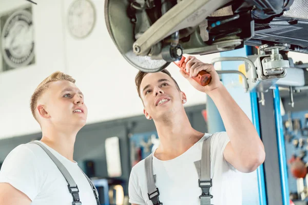 Zkušený Automechanika učí učni o kotoučové brzdy — Stock fotografie