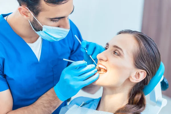 Mooie vrouw kijken met vertrouwen naar haar betrouwbare tandarts — Stockfoto