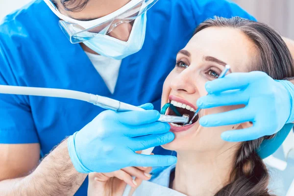 Giovane donna durante il trattamento orale indolore in un moderno studio dentistico — Foto Stock