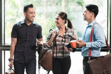 Üç genç ve neşeli çalışanları sabah konuşurken kendi işyerinde