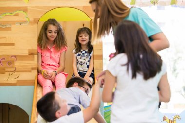 Genç bir öğretmen tarafından denetimli çalma süresi sırasında gülümseyen şirin kızlar