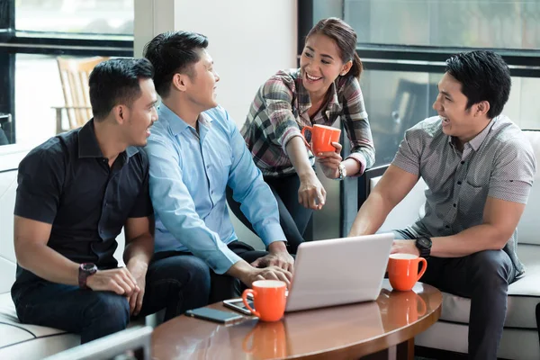 Twee vrolijke jonge mannen die een laptop gebruikt terwijl het delen van zakelijke ideeën — Stockfoto