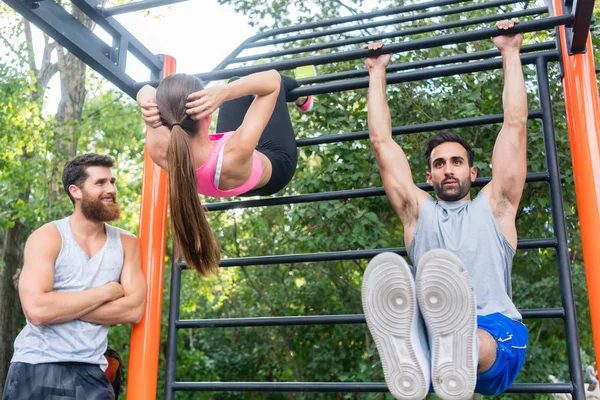 Bonito jovem fazendo levantamentos perna durante seis-packs abs treino — Fotografia de Stock