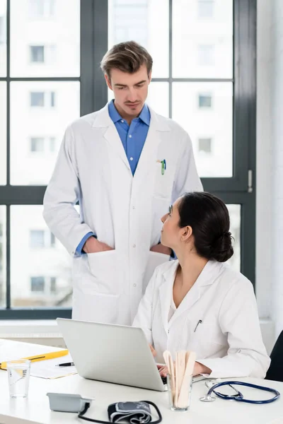 Doktor ve eczacı bilgi üstünde a laptop bir hastanede kontrol — Stok fotoğraf