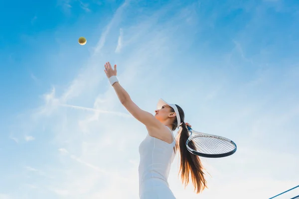 Nainen pelaa tennistä antaa palvelua — kuvapankkivalokuva