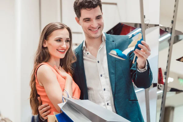 Mujer con su hombre mirando los zapatos azules en la tienda — Foto de Stock