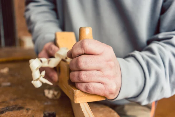 Mano de un carpintero mayor con cepilladora de madera — Foto de Stock