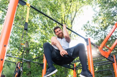 Tek kollu pull-up park barda asılı iken yapan güçlü genç erkek