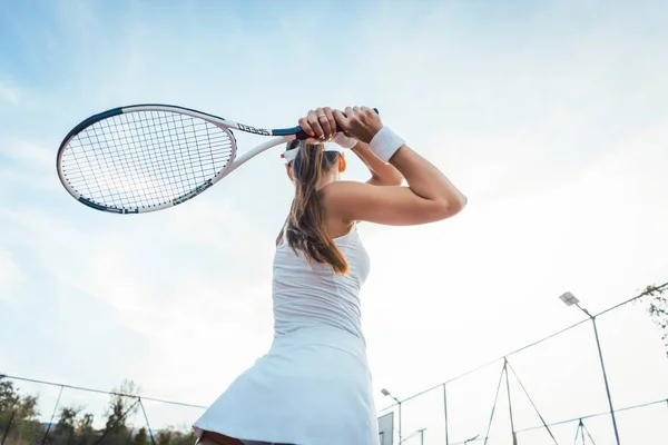 Vrouw geven terug spelen tennis — Stockfoto