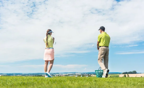 Mujer joven practicando el movimiento correcto durante la clase de golf al aire libre —  Fotos de Stock