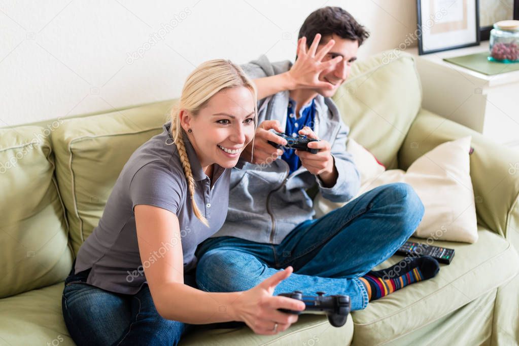 Funny young couple playing together a video game on console