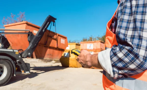 Hombre carga de la construcción contenedor de escombros en camión — Foto de Stock