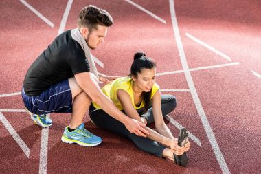 Erkek ve kadın kül üzerine spor arena germe izlemek