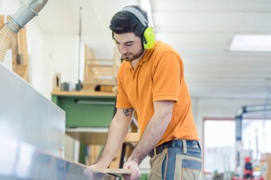 Marangoz mobilya fabrikasında makine üzerinde çalışan
