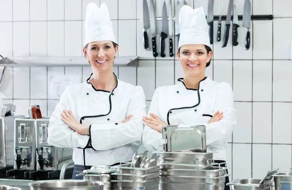 Kockar som bär arbetskläder i industriella kök — Stockfoto