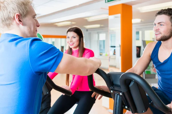 Grupo de hombres y mujeres haciendo entrenamiento cardiovascular en el gimnasio — Foto de Stock