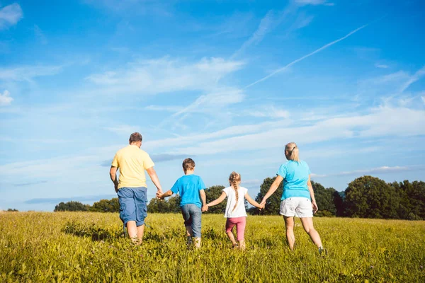 Familie hand in hand loopt over de weide — Stockfoto