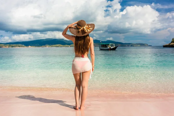 Atractiva joven mujer con sombrero de paja y falda de natación de malla en la playa tropical — Foto de Stock