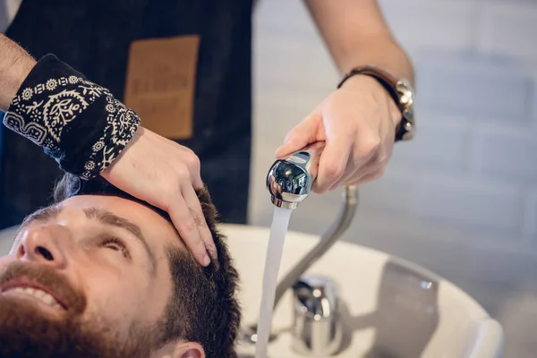 Primer plano de las manos de un peluquero experto que da un lavado de pelo —  Fotos de Stock