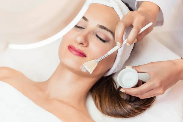 Close-up of a beautiful woman relaxing during facial treatment in beauty center — Stock Photo, Image