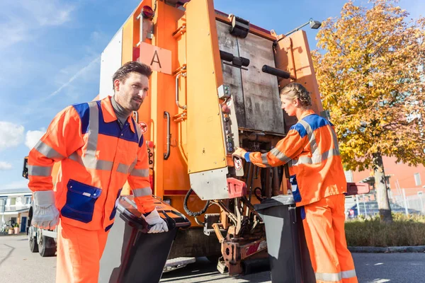 Afval verzamelaar aangrijpend handvat van vuilniswagen — Stockfoto