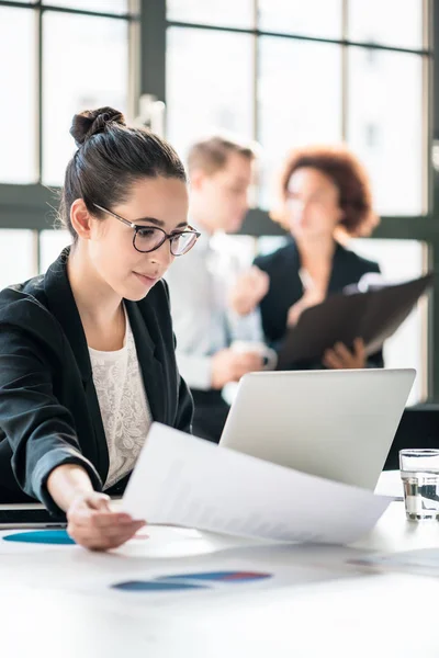 Dos jóvenes empleados malintencionados chismorreando sobre su colega — Foto de Stock