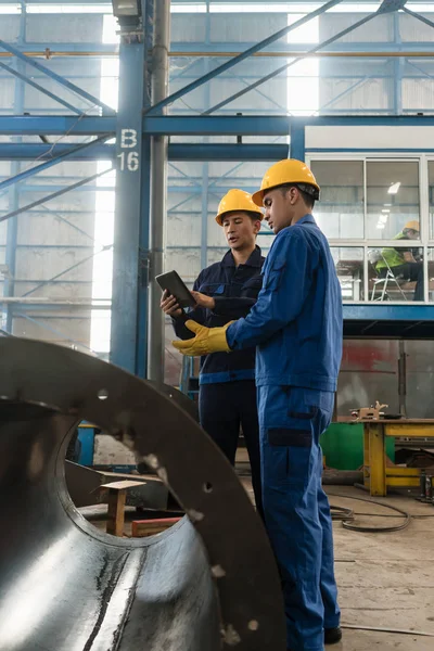 Expertos revisando información sobre tableta PC en una fábrica moderna — Foto de Stock