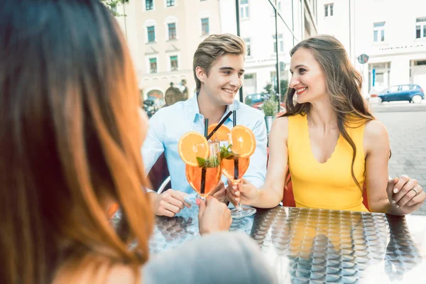 Coppia felice brindare con la loro amica in comune in un ristorante alla moda — Foto Stock