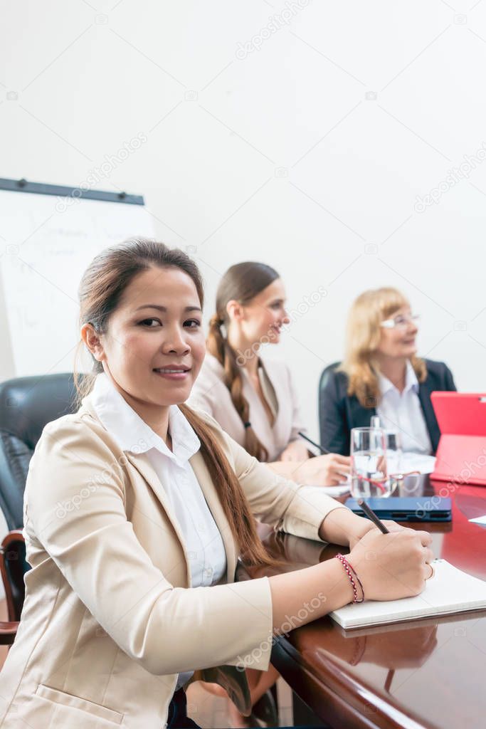 Portrait of a confident Asian business woman during a decision-making meeting