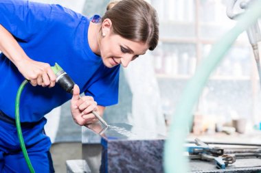 Craftswoman mezar taşı üzerinde çalışan taşçı fabrikasında 